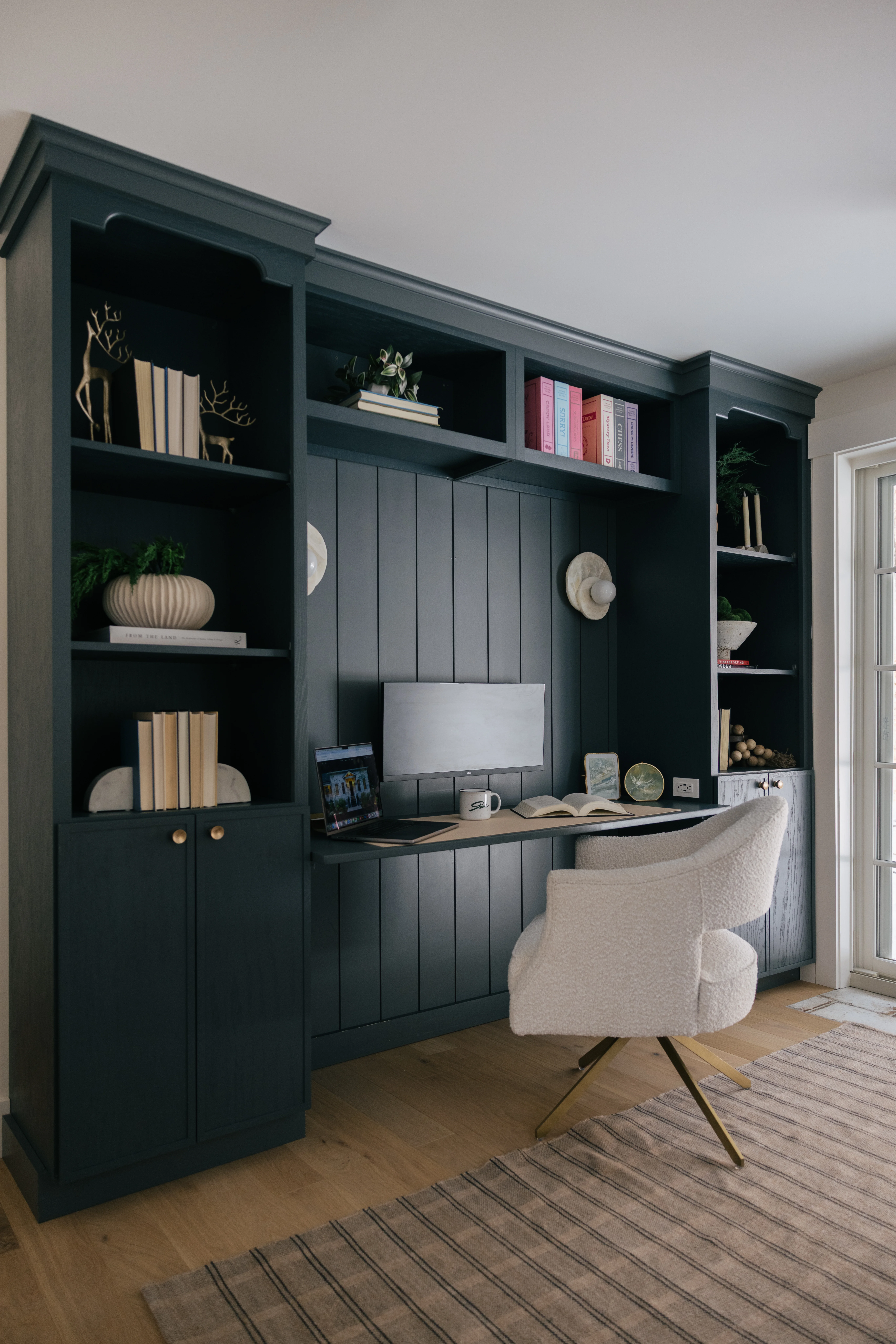 Library desk workspace with built-in shelving, task lighting, and comfortable seating